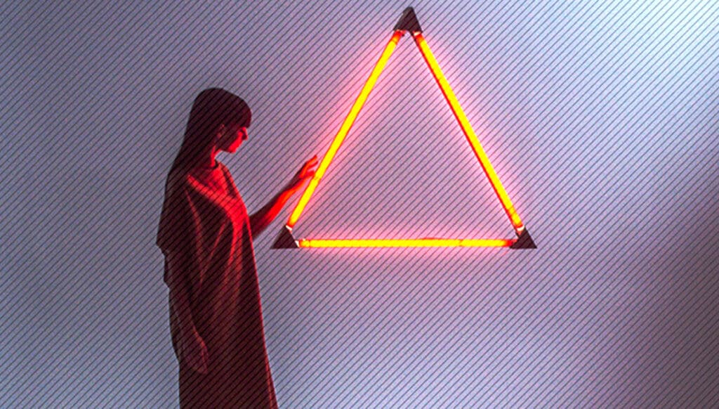 [:fr]Extrait de Fashion Fiction mettant en scène une jeune femme a proximité d’un grand triangle équilatéral illuminé en rouge sur un fond blanc[:]